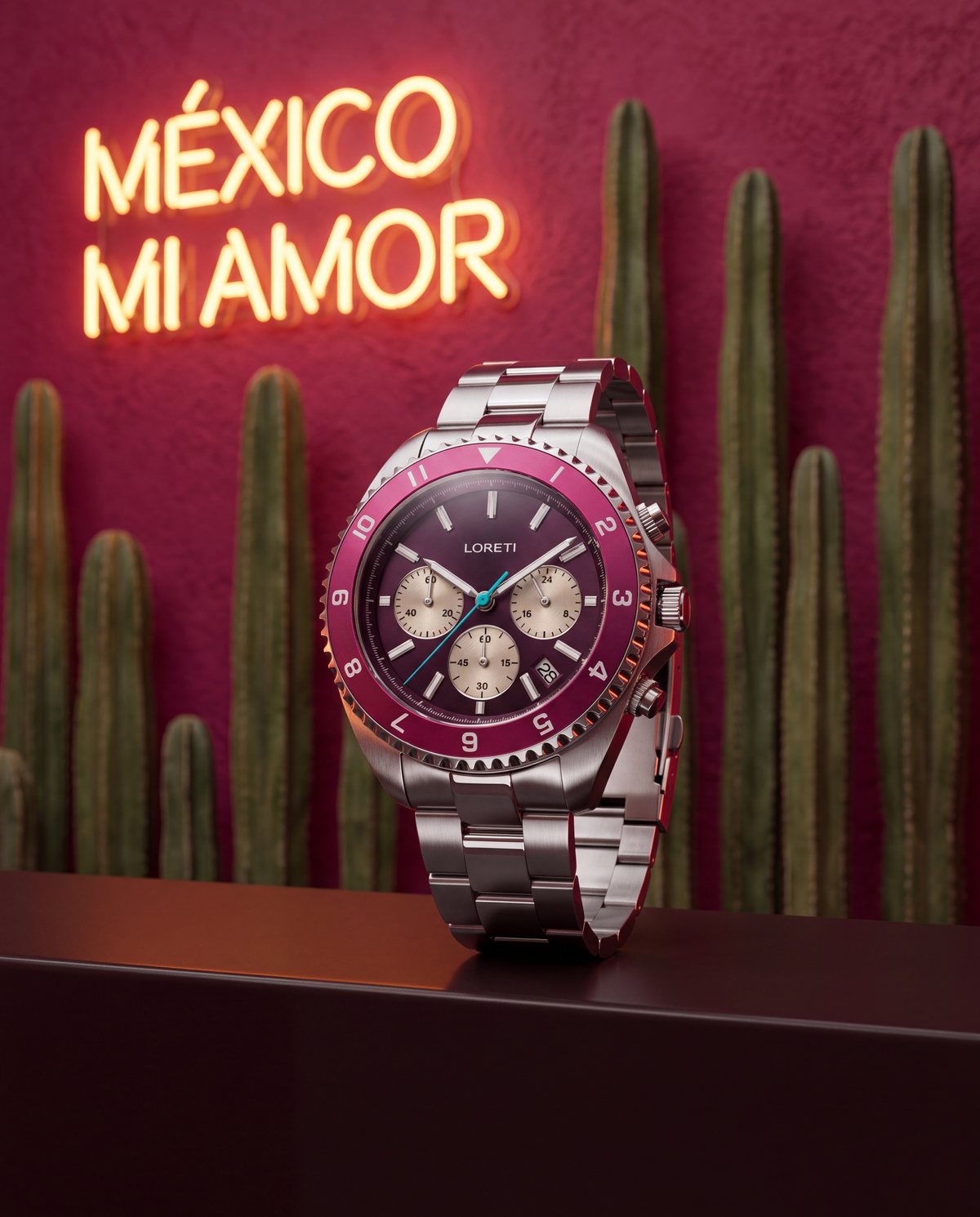The Ascari Mexico on a dark ledge in front of a fuchsia wall with cacti and a neon sign reading México mi amor
