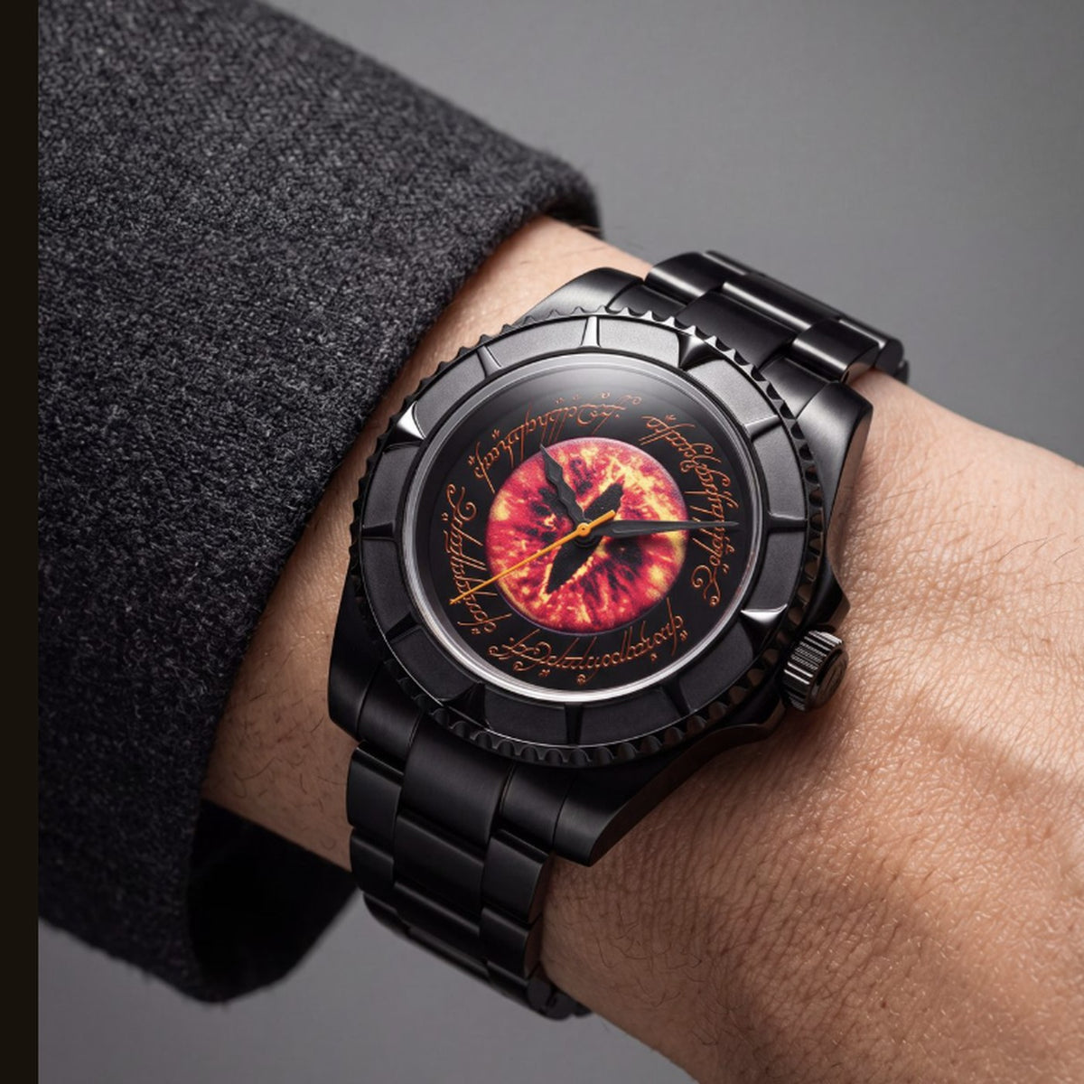 The Sauron watch worn on the wrist on its black steel bracelet, the burning Eye dial above a charcoal knit cuff